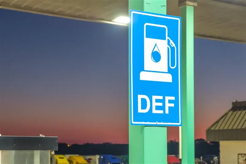 Sign at gas station reads "DEF," showcasing the availability of Diesel Exhaust Fluid for heavy-duty vehicle compliance.